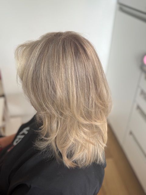 Blond, luchtig kapsel, net geknipt bij een klant thuis in de woonkamer